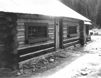Exterior photograph showing the horizontally laid, peeled round logs with saddle-notched corners. © Parks Canada