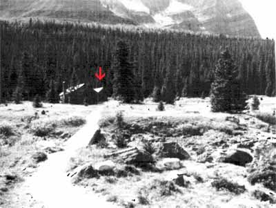 Panoramic view of the Elizabeth Parker Hut (left) and Wiwaxy Lodge (right)and the ongoing relationship of the Wiwaxy Lodge to its natural landscape on the shore of Lake O’Hara, surrounded by mature trees, 1987. © Public Works Canada / Ministère des Travaux publics, A. Powter, 1987