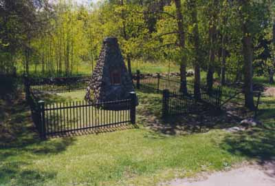 General view of the Historic Sites and Monuments Board of Canada stone cairn, near the site of the 1757 battle, marking the location of Bloody Creek National Historic Site of Canada. (© Agence Parcs Canada / Parks Canada Agency, Unité de gestion de la Nouvelle-Écosse continentale / Mainland Nova Scotia Field Unit.)
