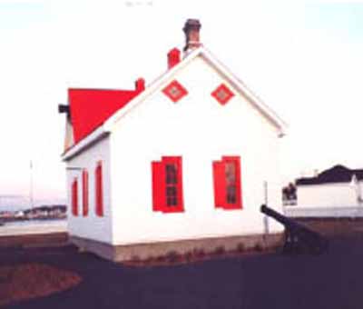 Vue en angle du bâtiment du criard de brume au lieu historique national du Canada du Phare-de-Pointe-au-Père, 1993. © Agence Parcs Canada / Parks Canada Agency, 1993.