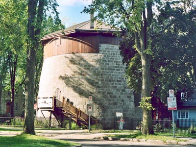 General view of Québec Martello Towers, showing their squat, cylindrical, two-storey massing with slightly inclining exterior walls, 2003. © Parks Canada Agency / Agence Parcs Canada, 2003.
