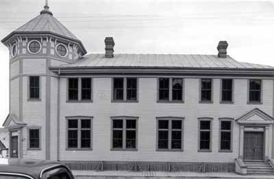 View of the side of the Post Office, showing the building's exterior, which is modest but carefully detailed and its Classical design, in keeping with other Dawson City federal buildings, 1987. © Parks Canada | Parcs Canada, 1987.