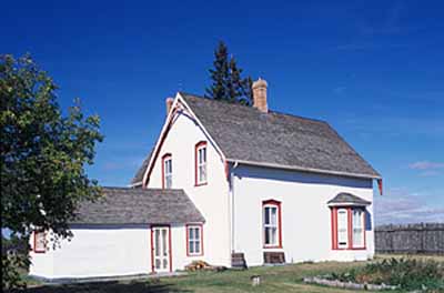General view of the rear of the Commanding Officer’s Residence showing the decorative gable-end trefoils and bargeboard, bay window, and decorative treatment of structural openings, 2003. © Parks Canada | Parcs Canada, M. Fieguth, 2003.