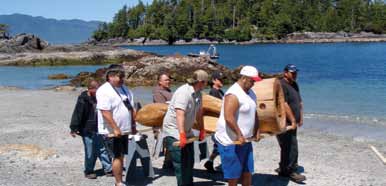 Tseshaht members and Pacific Rim National Park Reserve Public Safety staff transporting the House Post from the boat to the final resting place