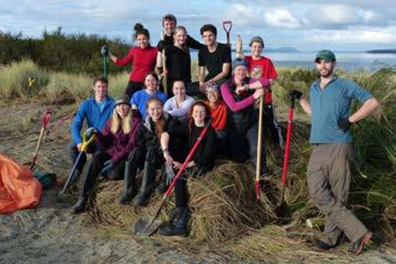 Group portrait of volunteer workers on a beach.