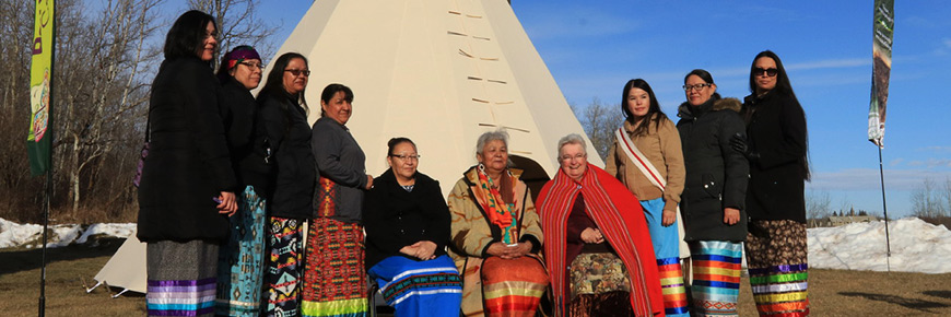 Women from Treaty 6, Treaty 7 and the Metis Nation of Alberta pose for a photo in front of a tipi after the ceremonial sendoff of bison sent from Elk Island National Park to Banff National Park in 2017.