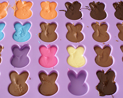 Different-coloured chocolate bunnies in a silicon mould