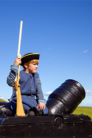 Garçon assis sur un canon, lieu historique national Fort Beauséjou