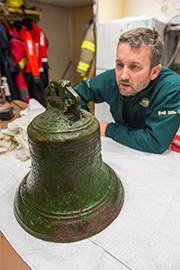 Un archéologue de Parcs Canada examine la cloche du HMS Erebus