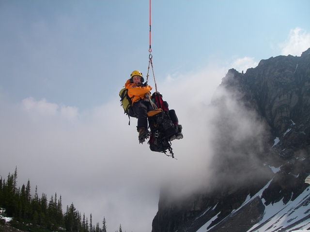 Le spécialiste de la Sécurité des visiteurs de Parcs Canada est hélitreuillé avec le deuxième grimpeur égaré.