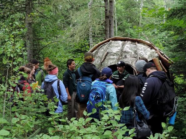 Un interprète de Parcs Canada expliquant le wigwam en dôme fait d’écorce de bouleau