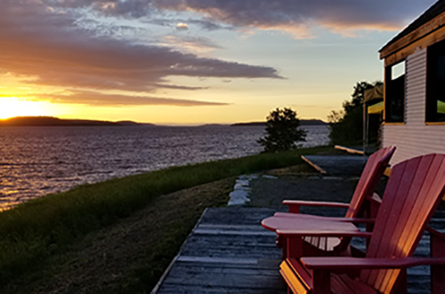 Two Parks Canada red chairs in front of the Lake Timiskaming