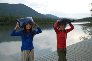 Two young visitors carry water back to their campsite in Nahanni National Park Reserve of Canada.
